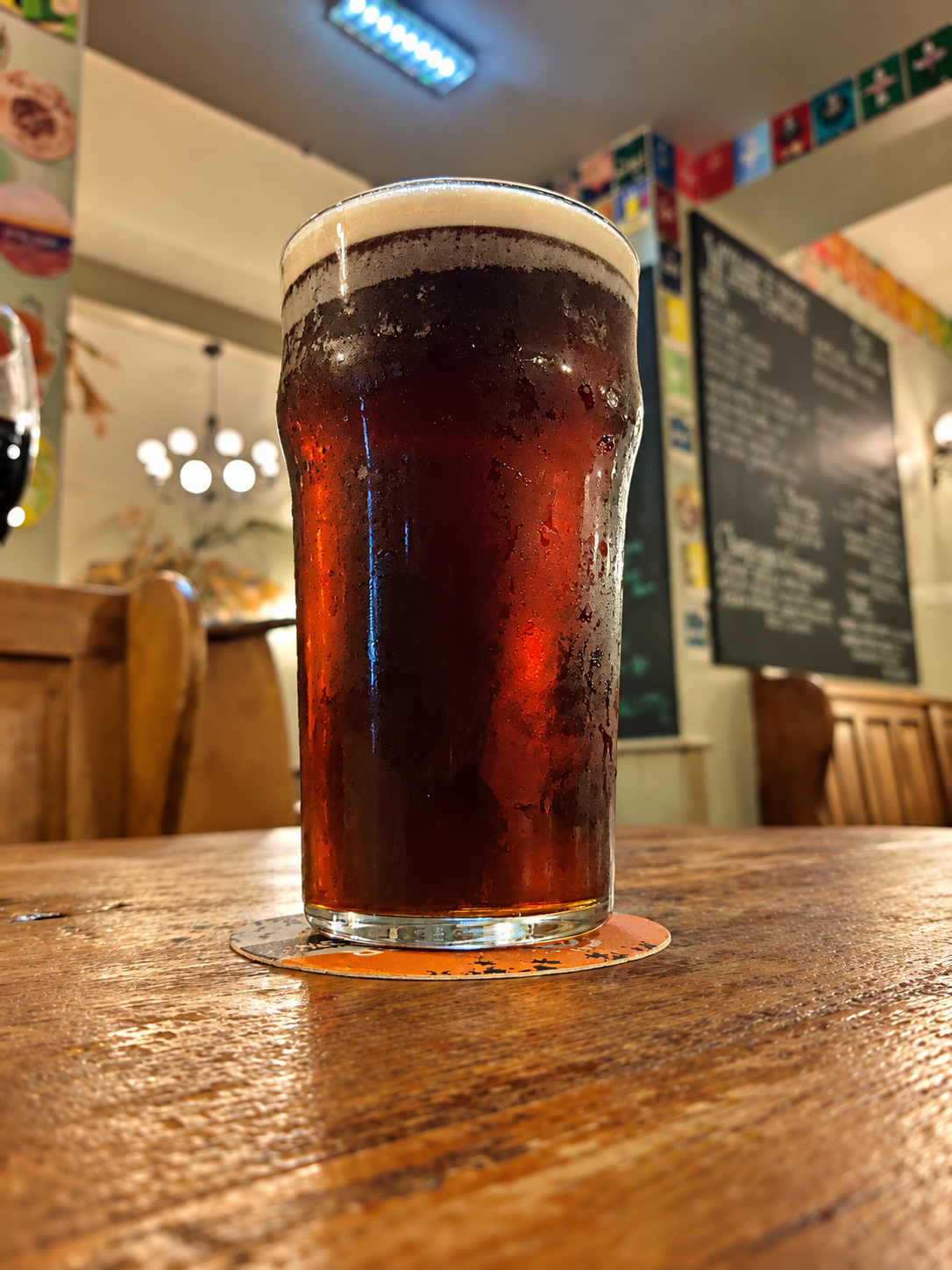A pint of amber ale on a wooden pub table