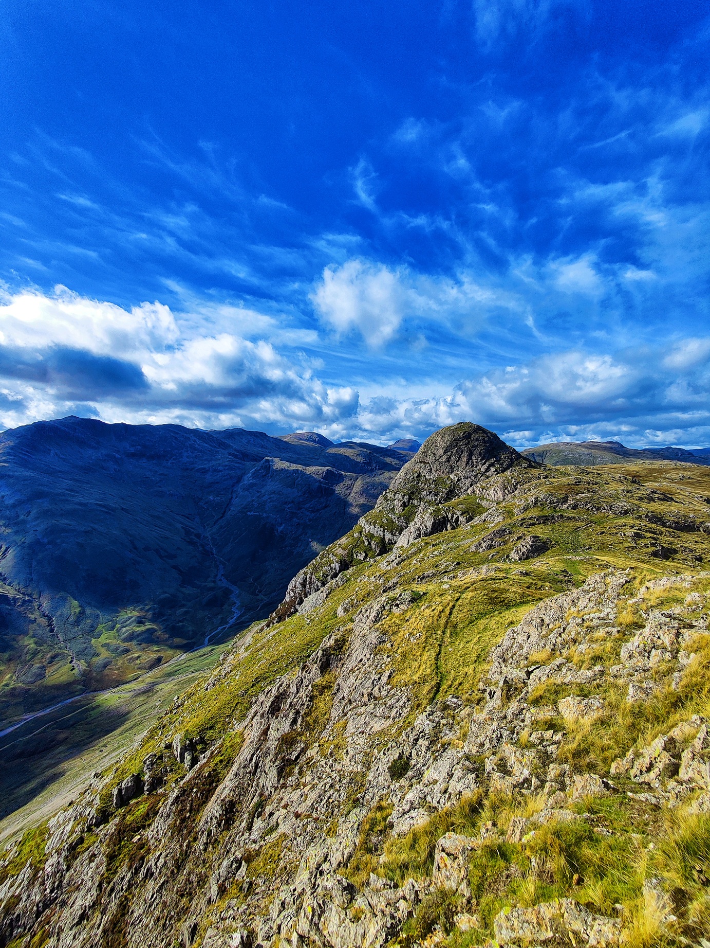 Rocky Lake District fells beneath a blue sky